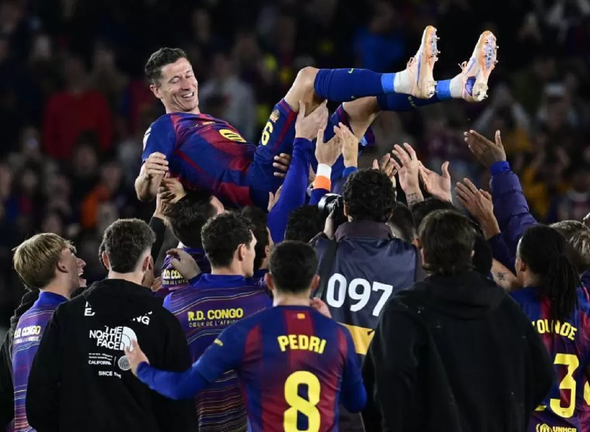 Robert Lewandowski diangkat ke udara oleh rekan-rekan setimnya di Barcelona.
