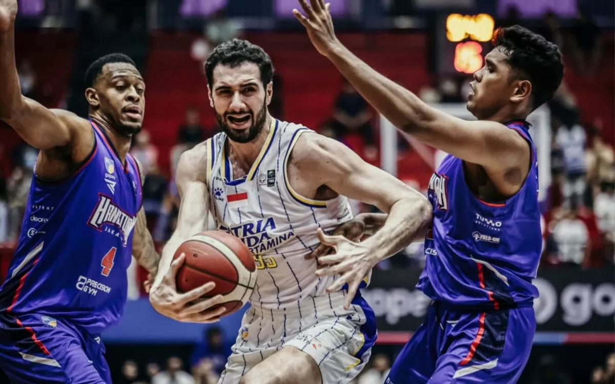Pemain asing Satria Muda Bandung, Giorgi Bezhanishvili mencoba melewati penjagaan dua pemain Hangtuah Jakarta. SM unggul 1-0 di Gim 1 playoff IBL 2026. (IBL Indonesia)