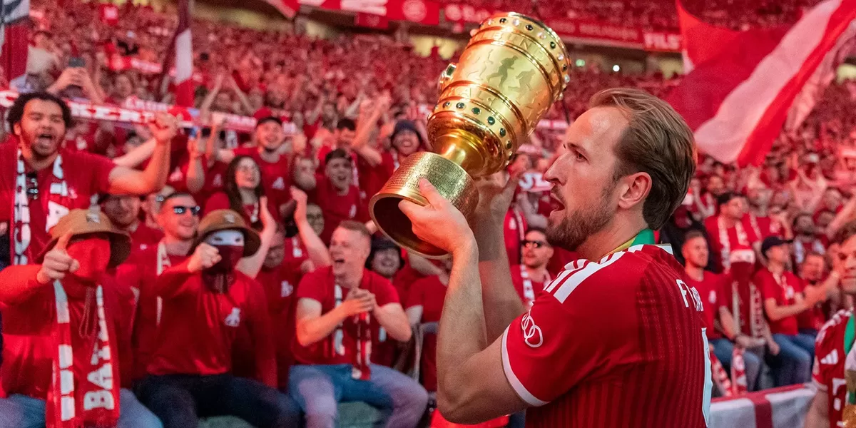 Harry Kane mengangkat trofi Piala Jerman untuk Bayern Muenchen.