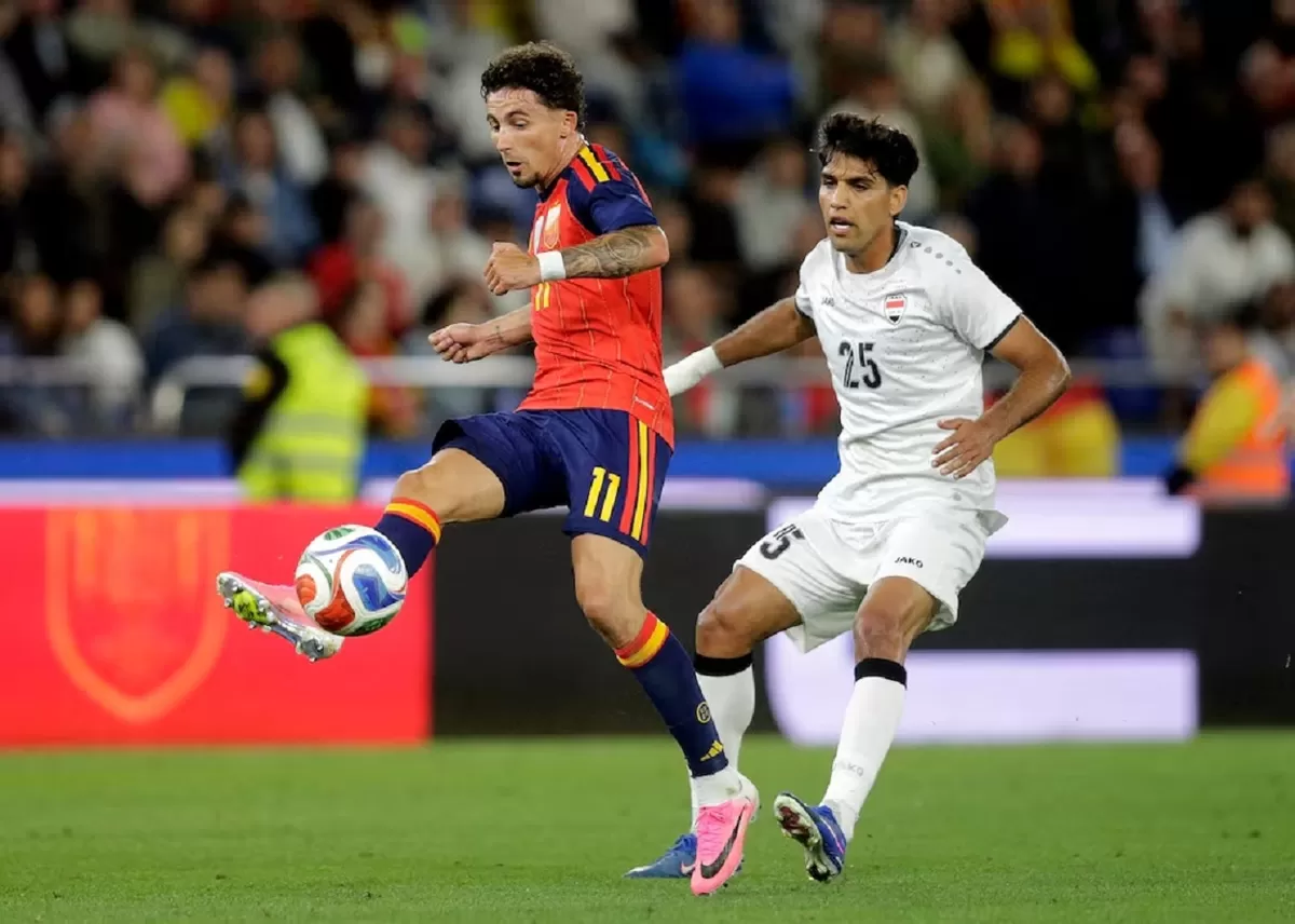 Pemain Spanyol Yeremy Pino beraksi dengan Mustafa Saadoon Irak.