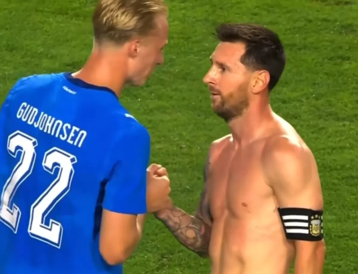 Lionel Messi disapa pemain Islandia Daniel Gudjohnsen.