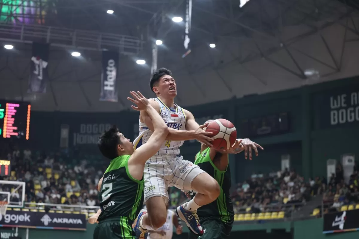 Pemain Satria Muda Bandung, Abraham Damar Grahita coba dihalangi dua pemain Bogor Horbills saat akan melakukan lay-up di Gim 4 semifinal IBL 2026, Jumat, 12 Juni. 