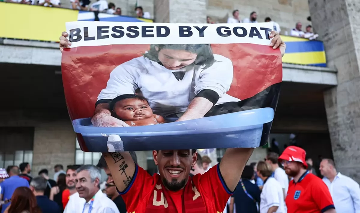 Seorang suporter membentangkan foto saat Messi memandikan Yamal. (FIFA)