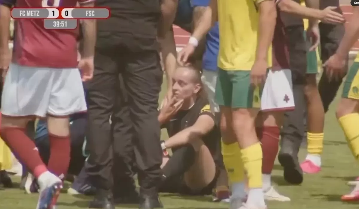 Wasit Prancis, Mathilde Demoncay tersungkur akibat dorongan kerusuhan antarpemain pria.