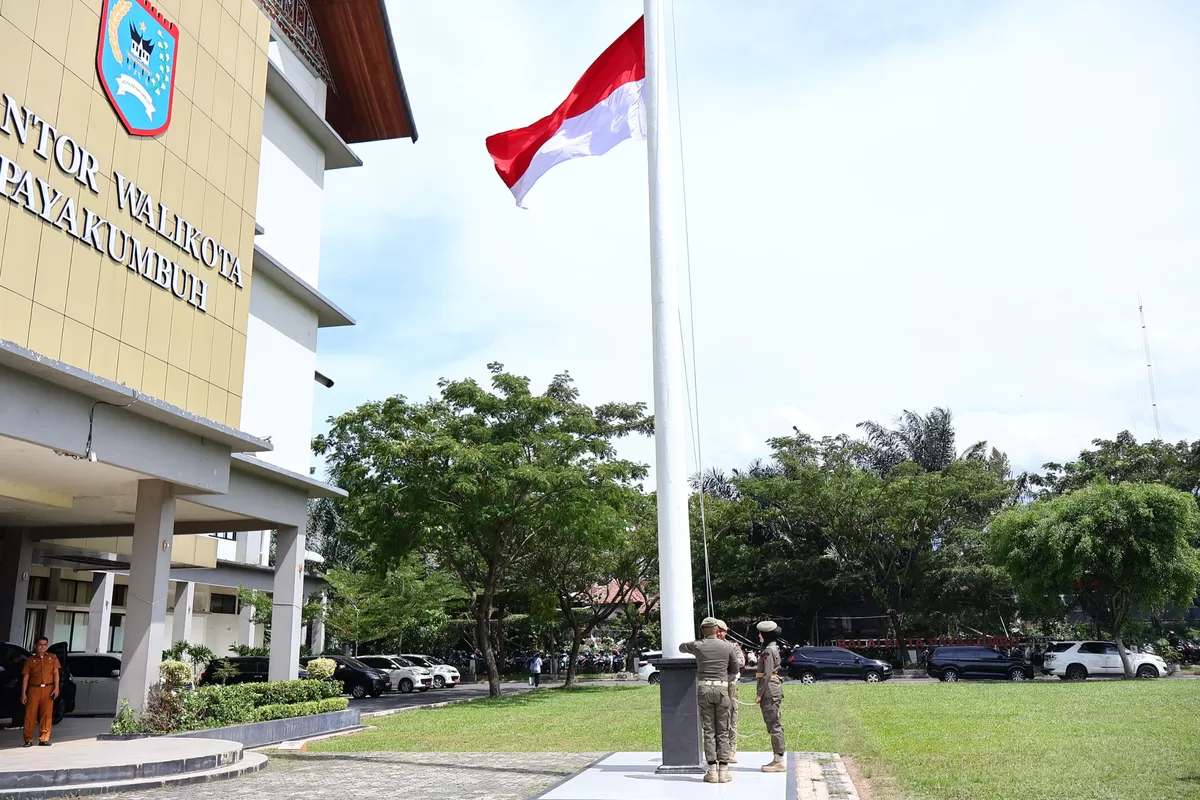 Petugas Satpol PP menaikkan Bendera Merah Putih setengah tiang di halaman Balai Kota Payakumbuh, Senin (2/3/2026). Pengibaran dilakukan sebagai bentuk penghormatan atas wafatnya Wakil Presiden ke-6 Republik Indonesia, Try Sutrisno.