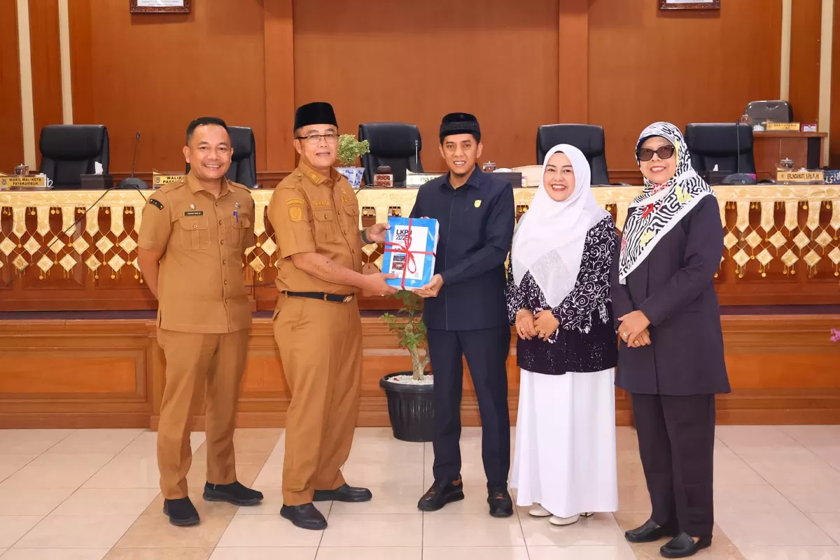 Sekretaris Daerah Kota Payakumbuh, Rida Ananda (kedua dari kiri, seragam dinas cokelat), menyerahkan dokumen Laporan Keterangan Pertanggungjawaban (LKPj) Wali Kota Payakumbuh Tahun Anggaran 2025 kepada Ketua DPRD Kota Payakumbuh (tengah, jas hitam), disaksikan jajaran pimpinan DPRD, dalam rapat paripurna di Gedung DPRD Kota Payakumbuh, Selasa (31/03/2026).