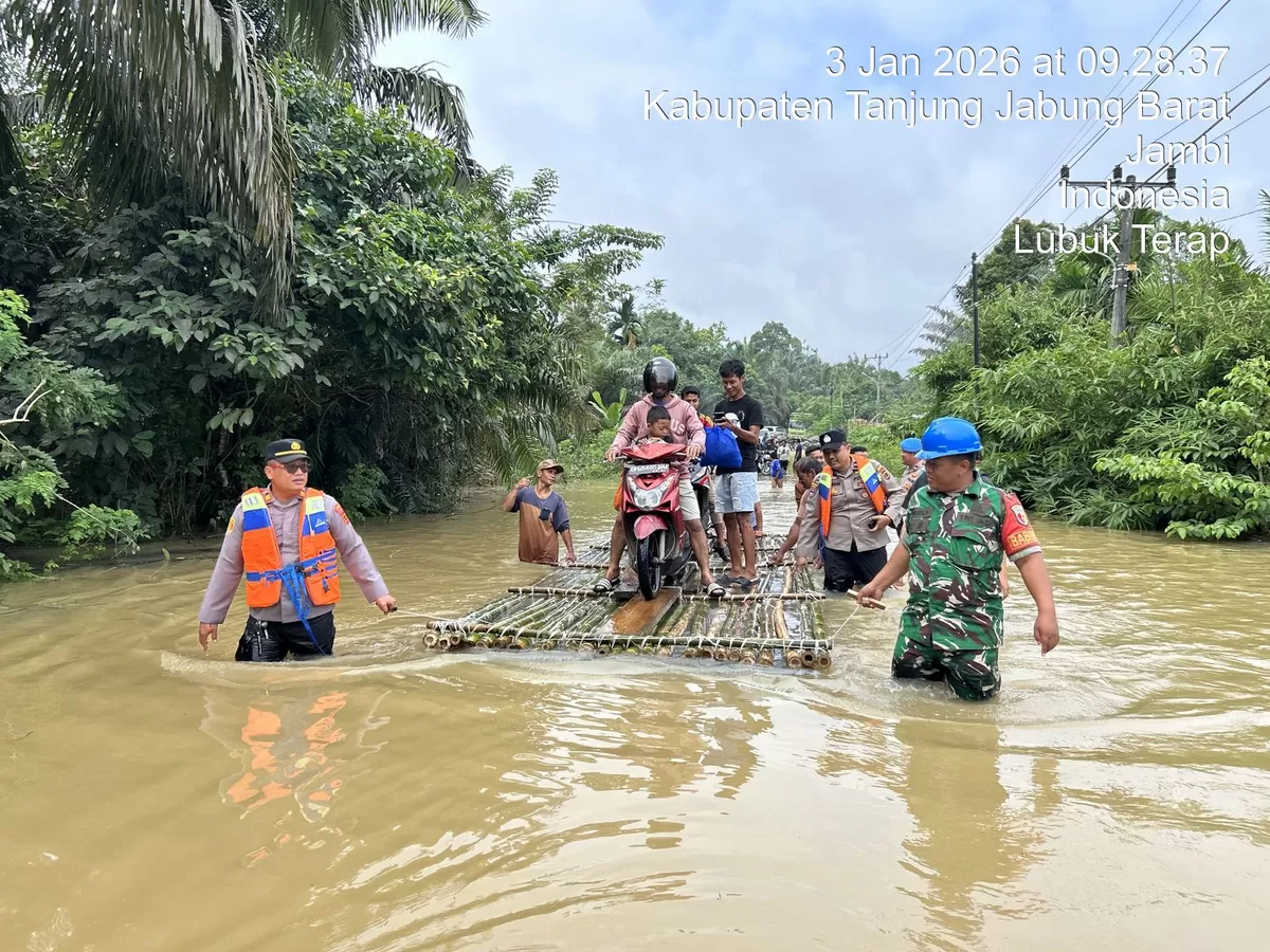 Polsek Merlung Pantau Debit Air Jalan Lintas Terendam Hingga 100 CM. (Doc. Humas Polres Tanjab Barat)