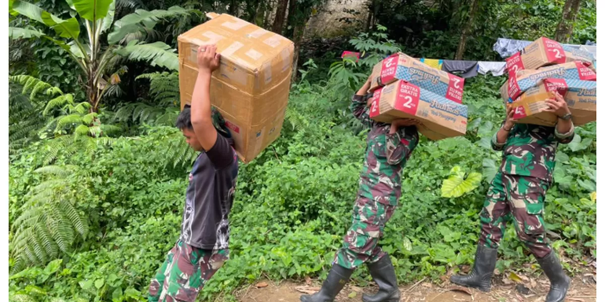 Anggota TNI dari Yonif 122/TD Menyalurkan Bantuan ke Kec.Sitahuis Tapteng Melalui Jalan Kaki. (Realitasonline.id/Dok)