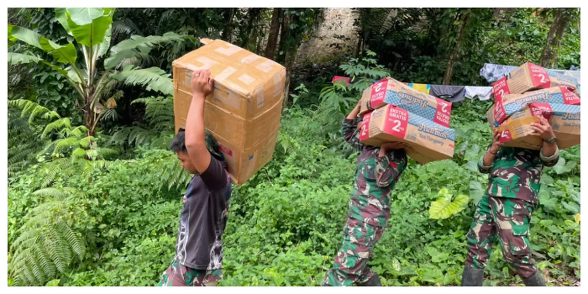 Personel TNI berjalan kaki memanggul bantuan logistik untuk warga terdampak bencana di Desa Nauli. (Realitasonline.id/Dok)
