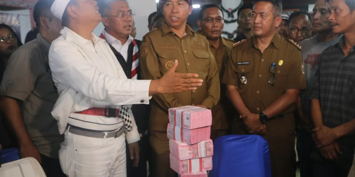 Gubernur Jabar Kang Dedi Mulyadi (KDM) saat menyerahkan uang tunai bantuan pembangunan rumah disaksikan Bupati Taput Dr. Jonius Taripar Hutabarat kepada kepala desa di galeri Dekranasda kemarin Senin (12/1/2026). (Realitasonline.id/AS)