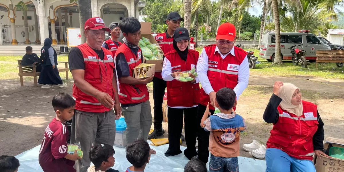 Ketua PMI Bireuen, Edi Saputra (berdiri kanan) menyerahkan bantuan untuk anak korban bencana banjir . Foto Dokumen Realitasonline. id