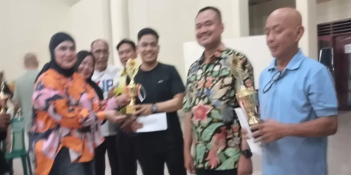 Ketua IKWI Sumut Fadia Achri Yulan menyerahkan piala kepada juara II pertandingan Domino piala Kapolrestabes pasangan Farianda Putra Sinik/Rifki WarisanMedan  (Realitas online.id/mis)