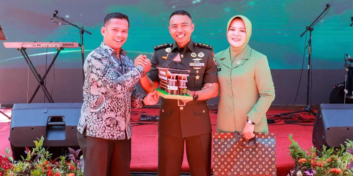 Sekda Junaedi Sitanggang memberikan cenderamata Miniatur Rumah Adat Simalungun (Realitasonline.id/RH)