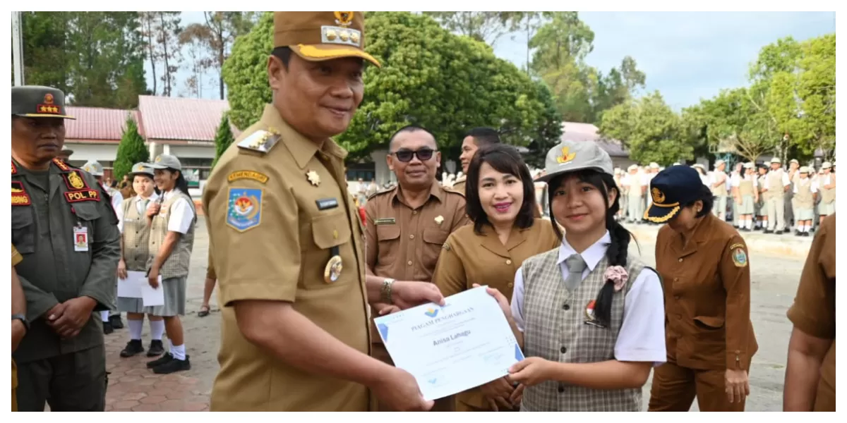 Bupati Humbahas Oloan P Nababan menyerahkan sertifikat bagi siswa berprestasi. (Realitasonline.id/Dok)