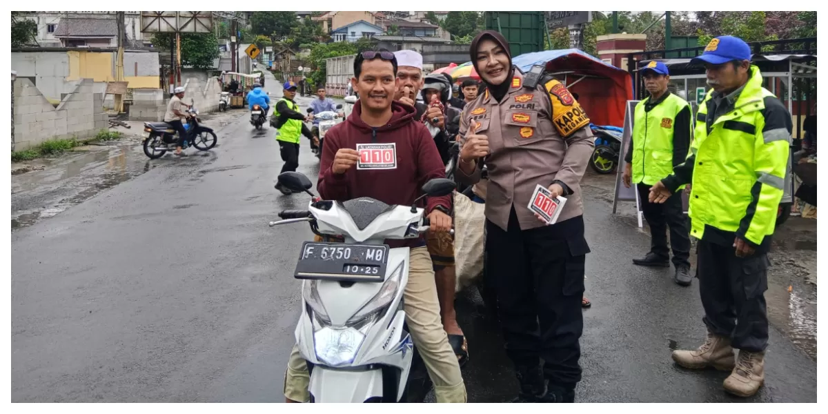 Kapolsek Megamendung AKP Desi Triana menyerahkan stiker layanan darurat 110 kepada pengendara saat kegiatan berbagi takjil Ramadan di Mako Polsek Megamendung, Kabupaten Bogor, Rabu (4/3/2026). (Realitasonline.id/Dok)