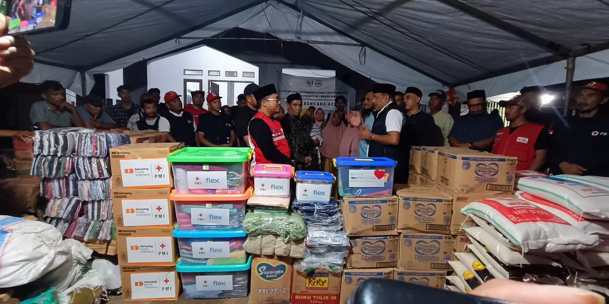 Bupati Bireuen, H. Mukhlis (rompi hitam) dan Ketua PMI Bireuen, Edi Saputra (rompi merah) menyerahkan bantuan uang penyintas banjir di Dusun Bivak, Desa Krueng Simpo, Kecamatan Juli, Kabupaten Bireuen. (Realitasonline.id/RZ)