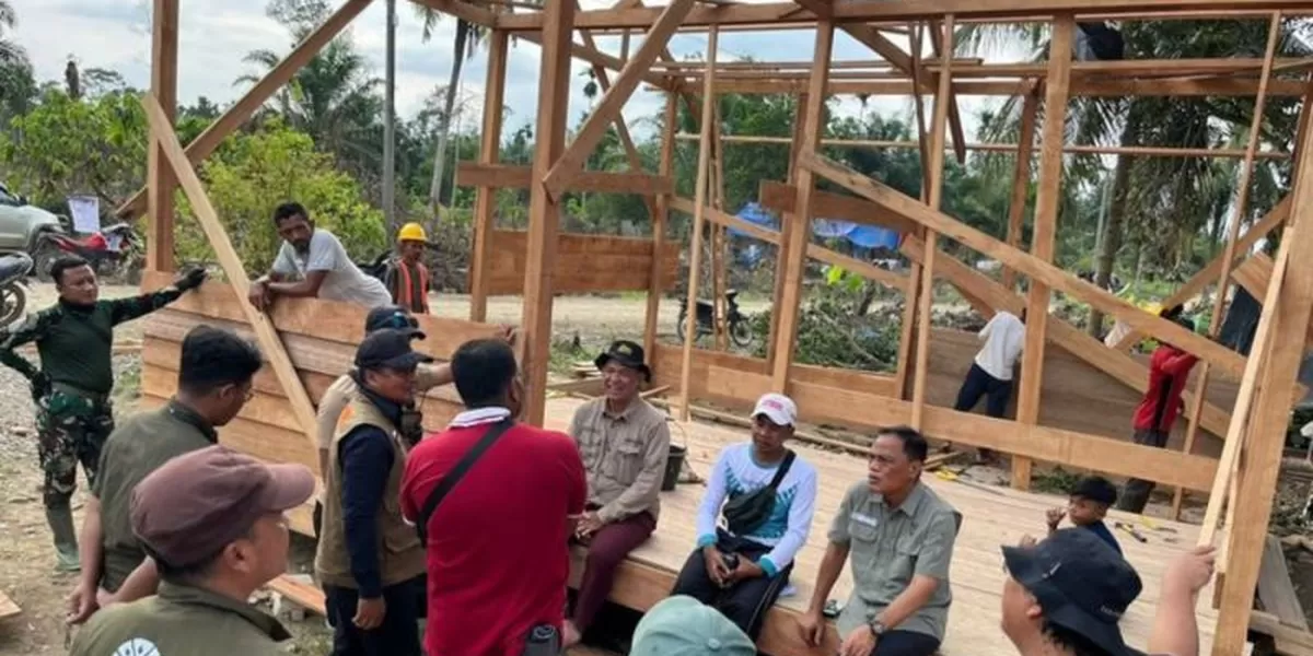 Petugas beristirahat di dekat pembangunan huntara menggunakan kayu terseret banjir di Aceh Utara, Aceh.  (ANTARA/HO-Kemenhut )