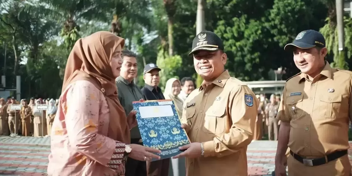 Walikota Depok, Supian Suri, menyerahkan SK pensiun kepada mantan Sekretaris Disdik Kota Depok, Tatik Wijaya.  (ist)