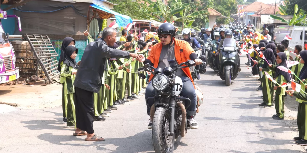 Bupati Subang Reynaldy Putra Andita Budi Raemi (Kang Rey) menyapa warga saat melintas di Desa Kihiyang, Kecamatan Binong. Disambut antusias pelajar yang berbaris sambil mengibarkan bendera merah putih. Kamis, 16 Juli 2026 (Dok. Istimewa)
