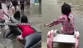 Di Tengah Bencana Banjir, Anak-anak Bekasi Tetap Ceria Main Air Bak Wahana Rekreasi