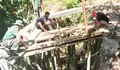 Proses Pembangunan Terus Berlanjut, Personel Koramil 02/Lirung Bersama Warga Pasang Maal Jembatan Perintis Garuda