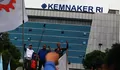 Meski Diguyur Hujan, Ratusan Buruh Tetap Kepung Kemnaker Tolak Aturan Outsourcing Baru