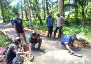 Babinsa Ramil 07/Miangas bersama warga berbaur dengan anggota Satgas karya bhakti skala besar dalam pengecoran jalan*