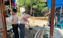 Sinergi Polri dan Warga: Personel Polsek Teluk Nibung Turun Tangan Renovasi Jembatan Merah Putih.
