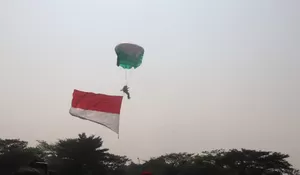 Jadi Hiburan Warga, Terjun Payung Kibarkan Tiga Bendera di Kirab Merah Putih 2024