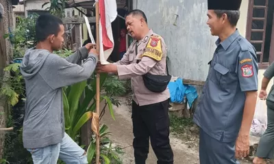Sambut HUT RI, Bhabinkamtibmas Polsek Tanjung Balai Utara Ajak Warga Pasang Bendera Merah Putih