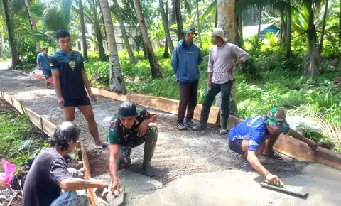 Babinsa Ramil 07/Miangas bersama warga berbaur dengan anggota Satgas karya bhakti skala besar dalam pengecoran jalan*