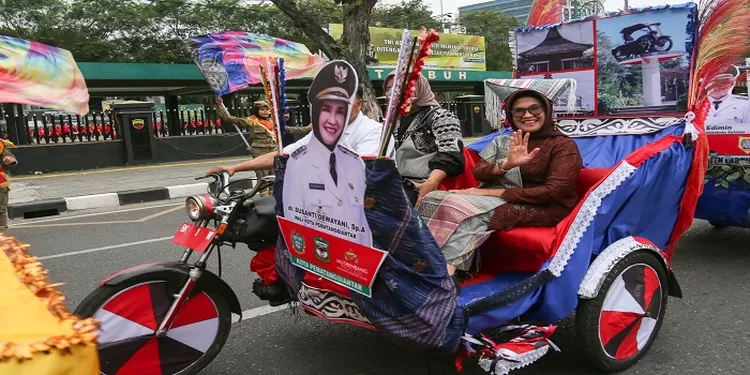 Wakikota Pematangsiantar Susanti Dewayani  mengenakan pakaian adat Simalungun yang didominasi warna cokelat naik becak naik becak bergerak dari rumah dinas Gubernur di Jalan Jenderal Sudirman Nomor