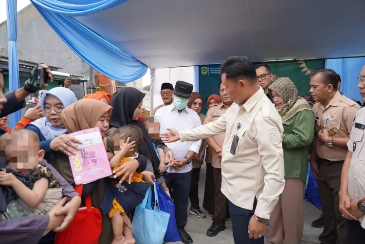 Pj Bupati Bogor Asmawa Tosepu menyerahkan bantuan Pemberian Makanan Tambahan kepada keluarga yang memiliki anak kategori gizi kurang di Desa Sumur Batu, Babakanmadang.