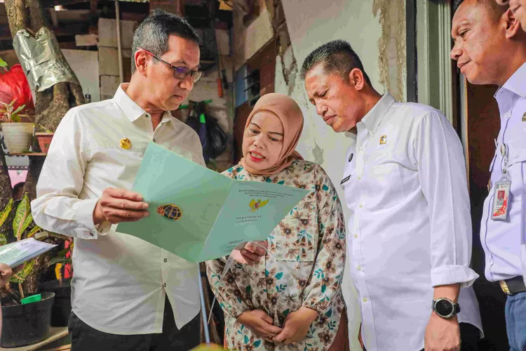 Pj Gubernur DKI Jakarta Heru Budi Hartono menunjukkan nama  dan alamat pemilik sertifikat tanah yang dibagikan kepada warga, Rabu (24/1/2024). 