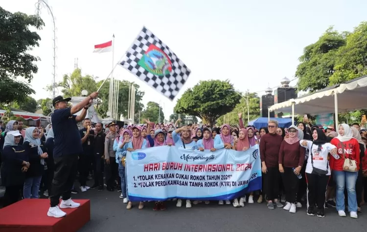 Pj Sugiat mengangkat bendera menandai pelepasan 400 pekerja dan buruh yang mengikuti fun walk bersama dimotori Dinas Tenaga Kerja Pemerintah Kabupaten Jombang dalam rangka memperingati Hari Buruh Internasional (May Day) di Jombang, 1 Mei 2024