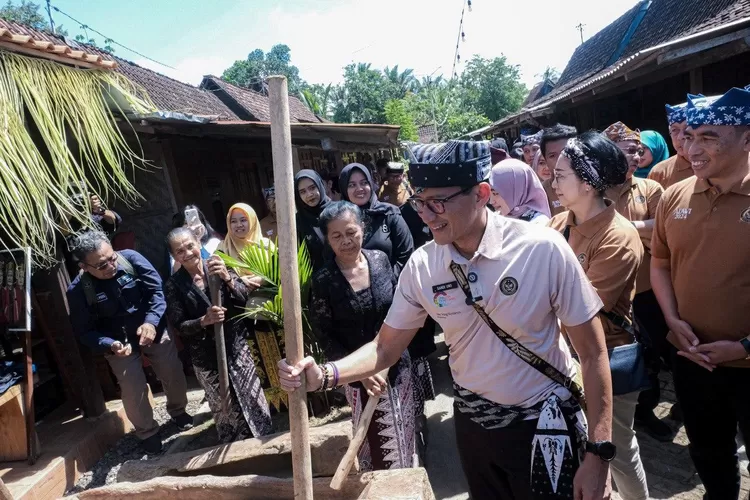 Menparekraf Sandiaga Salahuddin Uno saat menjajal tradisi Gedhogan saat visitasinya ke Desa Wisata Osing Kemiren, Banyuwangi, Sabtu (13/7/2024).