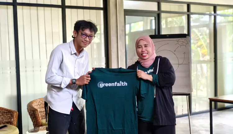Ageng perwakilan Lembaga Gemawan, Lembaga Pengembangan Masyarakat Swandiri yang berlokasi di Pontianak, Kalimantan Barat, menerima cindera mata dari Koordinator Nasional GreenFaith Indonesia, Hening Parlan, dalam acara Pelatihan Keadilan Iklim untuk Pemuda Lintas Iman yang digelar di Rumah Gesit Gem