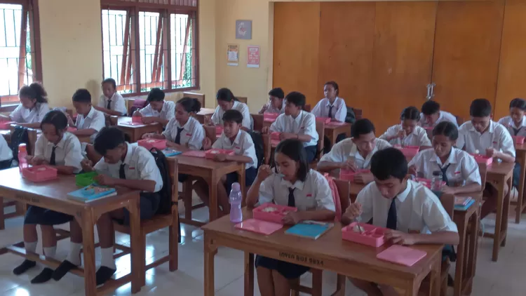 Siswa-siswi SMPN 1 Komodo Labuan Bajo menikmati makanan bergizi gratis, Senin (17/2/2025).