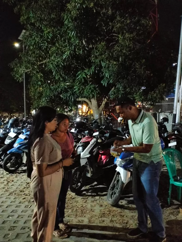 Petugas sedang melayani pengguna area parkir.