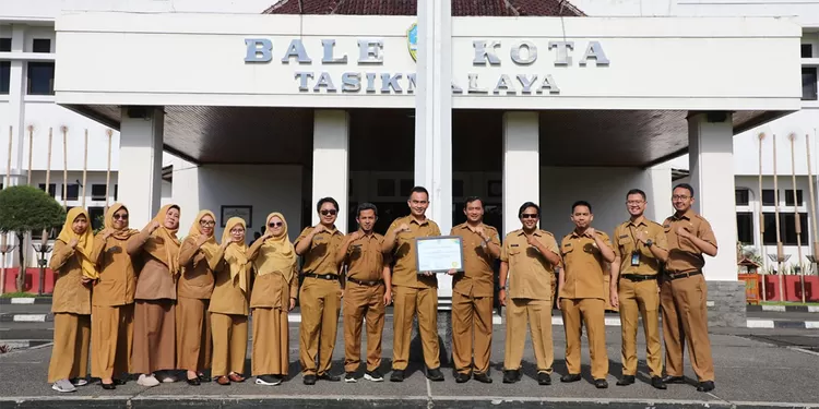 Kadis Amran Saefullah berfoto bersama jajaran Diskominfo Kota Tasikmalaya usai menerima penghargaan pada apel di Balekota, Senin (13/04/2026).