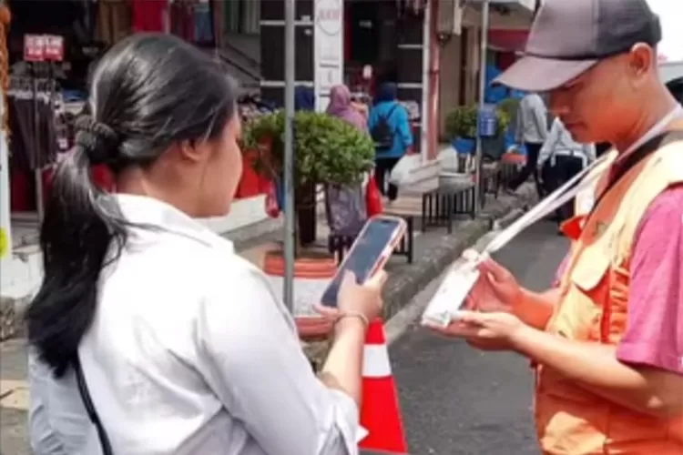 Seorang pengendara melakukan&nbsp;pembayaran non tunai&nbsp;di kawasan Jalan HZ. Mustofa Kota Tasikmalaya.