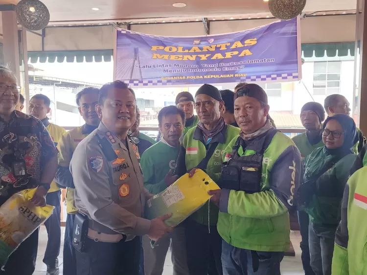 Dirlantas Polda Kepri KBP Taufiq Lukman Nurhidayat, S.I.K., M.H menyerahkan bantuan sembako kepada Komunitas Ojek Online Kota Batam.