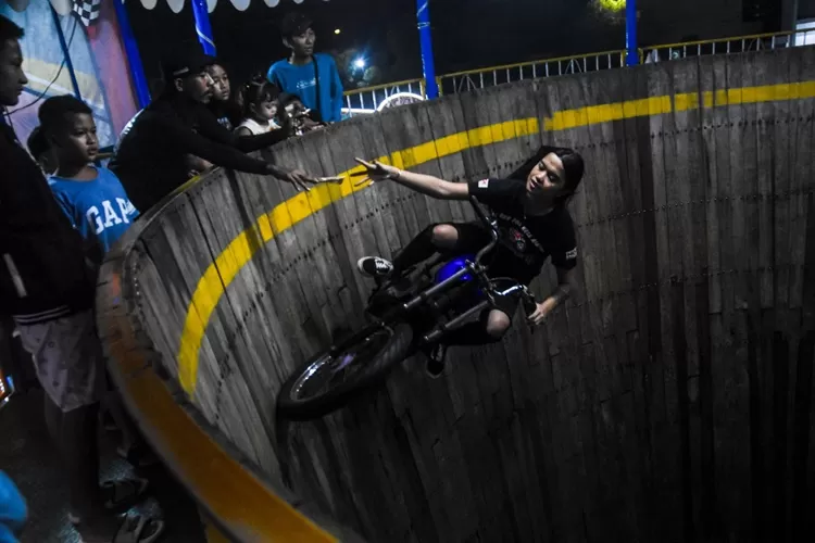 Salah satu aksi Karmila Purba yang mengambil uang saweran dari penonton. Sebagai Joki Tong Setan, pendapatan Karmila di luar dugaan. 