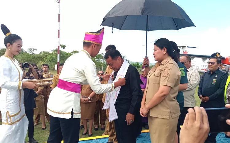 Ketua pwngadilan tinggi Manado di sambut dengan pengalungan stola kebesaran dari siswa SMA N 1 Mwlonguane