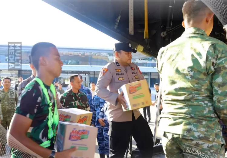 FOTO: Tampak personel saat mengangkat bantuan logistik di Lanud Hasanuddin, Makassar, Selasa, 18/8. (Dok. Humas Polda Sulsel)