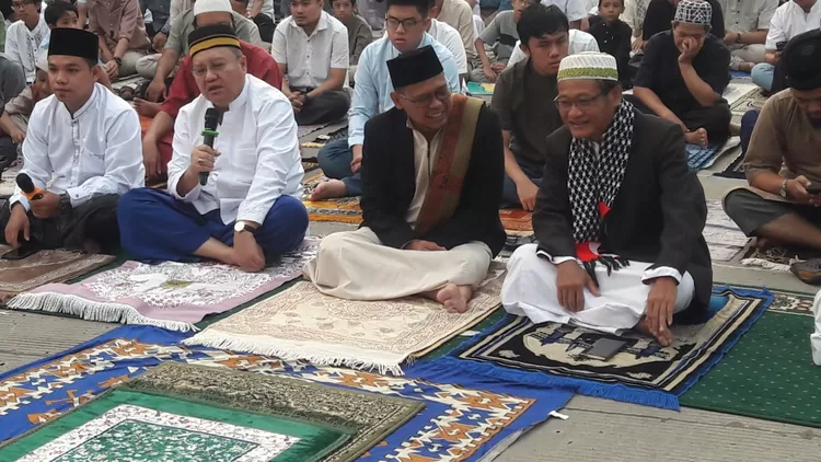 Wakil Walikota Depok, Imam Budi Hartono (peci hitam) bercengkrama dengan salah seorang jemaah Salat Idul Adha 1445 H