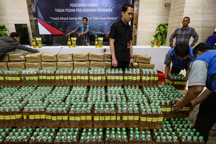 Petugas merapihkan barang bukti minyak goreng Minyakita dan mesin saat konferensi pers terkait produk minyak goreng Minyakita isi tidak sesuai kemasan di Lobby Bareskrim Polri, Jakarta, Selasa (11/3/2025). Bareskrim Polri melalui Satgas Pangan mengungkap kasus minyak goreng Minyakita yang takarannya tidak sesuai dengan label yang ada pada kemasan dengan menyita barang bukti 450 dus kemasan pouch, 180 kemasan pouch bag, 250 krat kemasan botol, mesin pengisi, dan timbangan. FOTO: SALMAN TOYIBI/JAWA POS