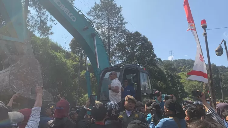 Ratusan pedagang kaki lima Puncak Bogor yang lapaknya dibongkar mengadang alat berat meminta Restoran Liwer Asep Stroberi ikut dibongkar.