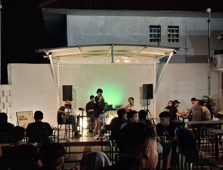 Band Candukustik saat membawakan penampilan live music di Komuna Kafe, Kabupaten Subang, menghibur pengunjung dengan sajian musik santai dan hangat di malam hari