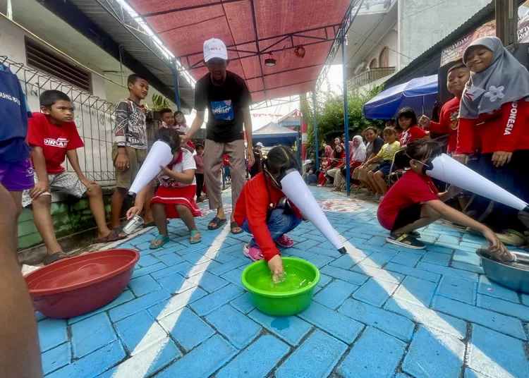 Lomba memasukkan air kedalam botol - Foto: Henri Lukmanul Hakim